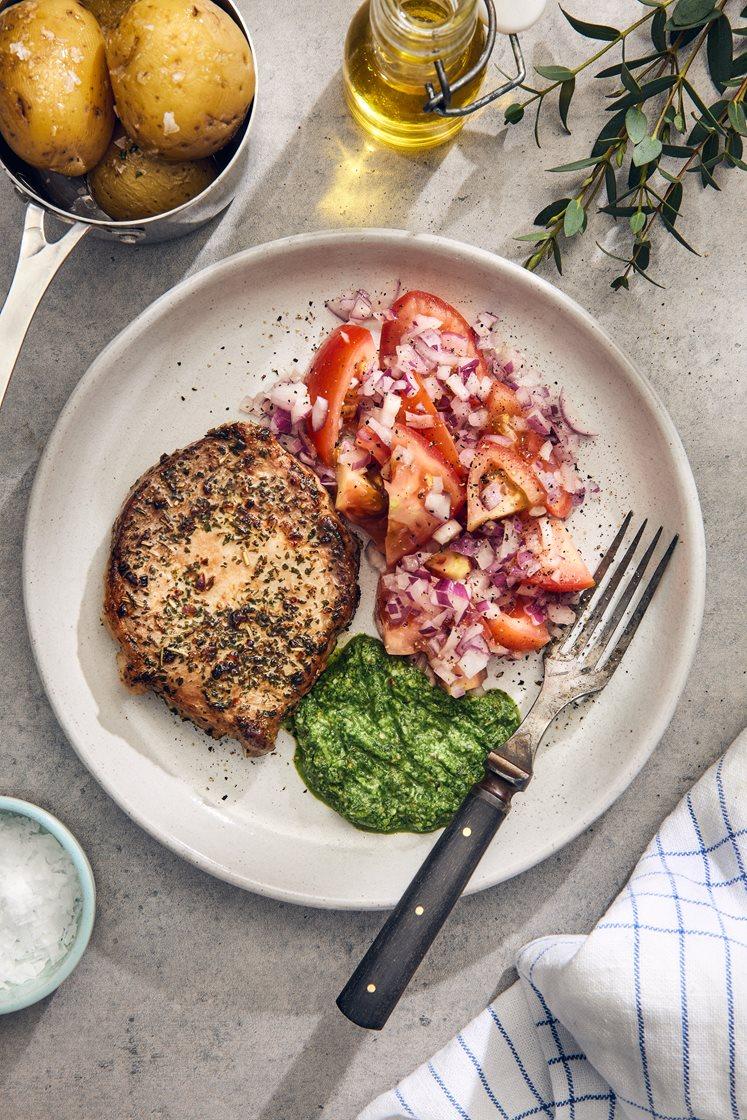 Örtstekt fläskkotlett med ruccoladressing, tomatsallad och potatis